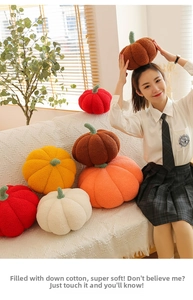 Detail of plush pumpkin pillows in various autumn colors on a textured white sofa