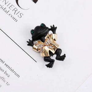 Elegant vintage frog brooch with black matte finish and sparkling gold crystal bow