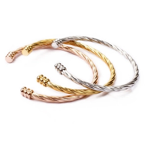 Détail de bracelets joncs torsadés en trois couleurs : or, argent et or rose élégant