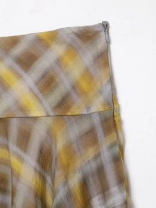 Detail of yellow plaid midi skirt showing linen texture and side invisible zipper
