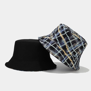 Reversible bucket hat featuring solid black and blue yellow plaid graffiti patterns