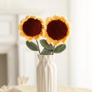 Detail of handcrafted crochet sunflower bouquet in a white ceramic vase for home decor