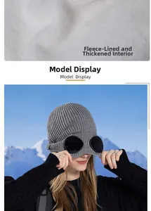 Detalle del forro polar blanco y gafas integradas en el gorro de punto gris de invierno