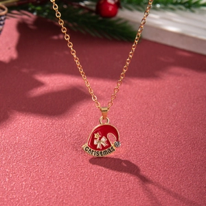 Detailed view of golden Christmas hat pendant with red enamel and sparkling crystal