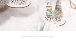 Macro detail of a Christmas glass ball with a boy figurine and a snowy tree inside