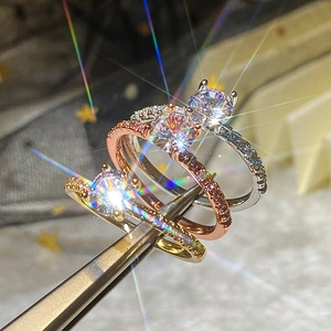 Detailed view of round zircon wedding rings in gold, rose gold and silver plating