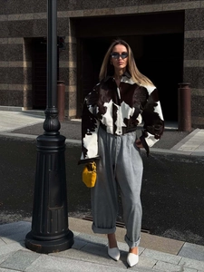 Detail of stylish black and white cow print faux fur jacket with street fashion styling