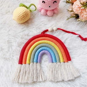 Close-up of handmade macrame rainbow car charm with colorful cotton tassels and wooden bead