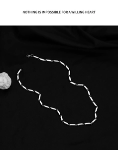Polished silver cylinder link chain necklace with lobster clasp on black silk fabric