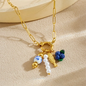 Collier en chaîne dorée avec perle en porcelaine, nacre, poisson et pendentifs myrtille