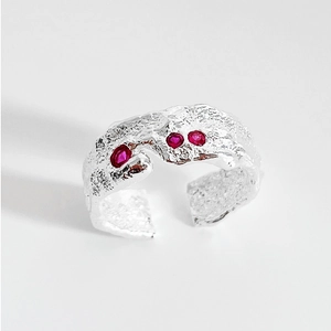 Detailed close-up of adjustable 925 silver ring with irregular lava texture and red stones