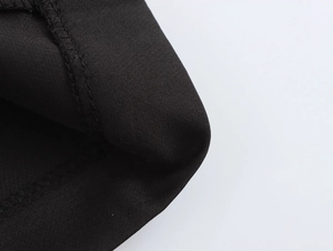 Detailed macro view of black beaded blazer dress fabric with fine stitching quality
