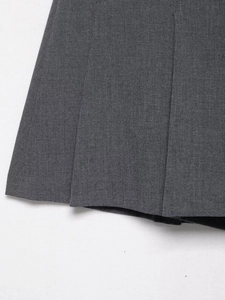 Detail of fixed pleats and fine stitching on dark grey pleated fabric with high texture