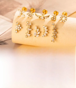 Macro detail of gold plated titanium steel ear studs with sparkling cubic zirconia designs