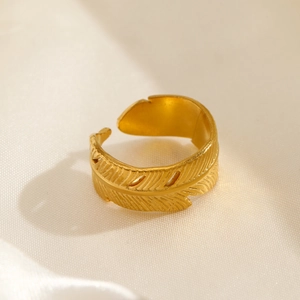 Golden feather design stainless steel open ring on soft silk fabric background