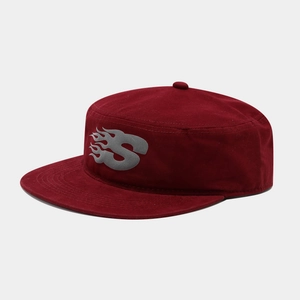 Macro detail of dark red flat top cap with gray flame S letter logo and cotton texture