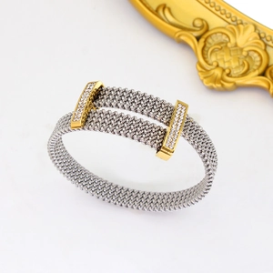 Detail of silver mesh bracelet with gold accents and sparkling cubic zirconia stones