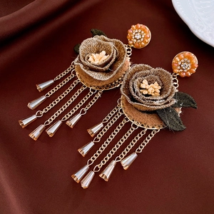 Détail de boucles d'oreilles vintage à fleurs avec roses brodées et strass brillants