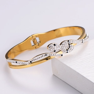 Detail of gold snake-shaped bangle featuring micro-paved white and black crystals