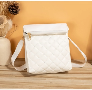 Detail of white quilted crossbody bag with diamond stitching and adjustable nylon strap
