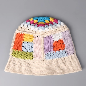 Detailed close-up of handmade crochet bucket hat featuring colorful floral patchwork patterns