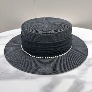 Close-up of black straw boater hat with refined pearl trim and woven texture detail