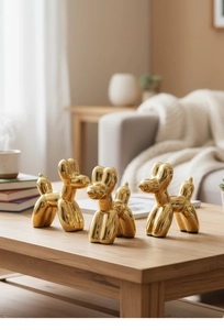 Dettaglio di tre sculture di cani palloncino dorati galvanizzati su un tavolo in legno