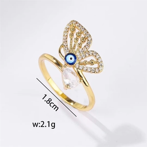 Close-up of golden butterfly ring with blue evil eye detail and white zircon micro-pave