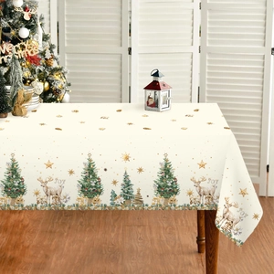 Waterproof Christmas tablecloth with reindeer and gold tree patterns on a wooden table