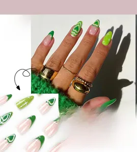 Detail of long almond nails featuring green swirl hearts and white star accents