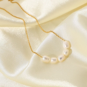 Detail of five high-luster freshwater pearls on a delicate 18K gold-plated necklace chain