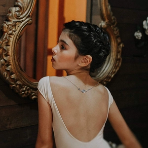 Close-up of silver rose pendant necklace draped elegantly on a model's back