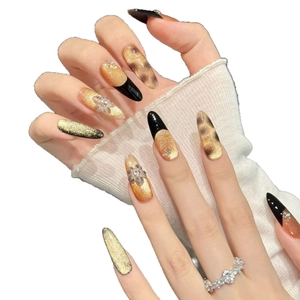 French black stiletto press-on nails with golden cat eye effect and 3D floral accents