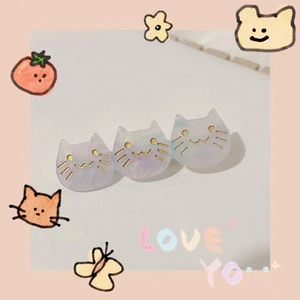 Macro detail of three purple marbled acetate cat hair clips with golden facial features