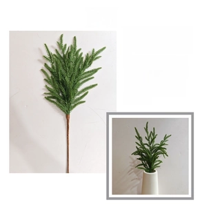Detailed macro shot of soft-touch PE Norfolk pine branches in a modern white ceramic vase