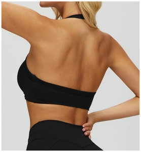 Close-up back view of black halter yoga bra and high waist leggings showing muscle contour