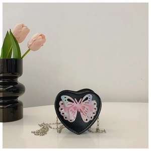 Close-up of heart-shaped girls shoulder bag with sparkling sequin butterfly detail