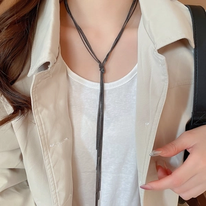 Detail of dark grey multi-layer metal chain necklace with long knotted fringe tassel