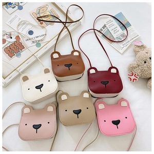 Detailed flat lay of cute bear-shaped kids shoulder bags in six vibrant PU leather colors