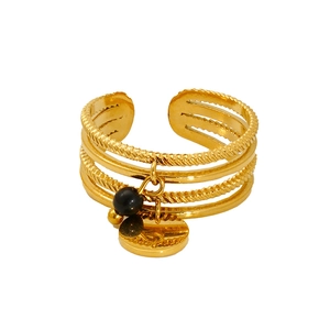 Detail of 18K gold-plated layered open ring featuring black stone and round metal charms
