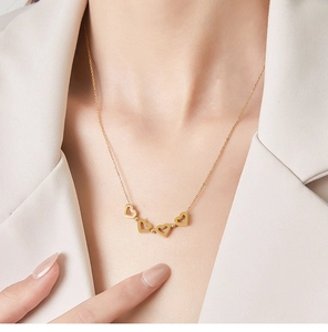 Détail du collier trèfle en titane plaqué or 18K avec quatre breloques en forme de cœur