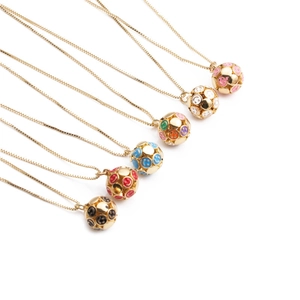 Detail of gold necklaces featuring colorful smiley face pendants in pink, blue, and red