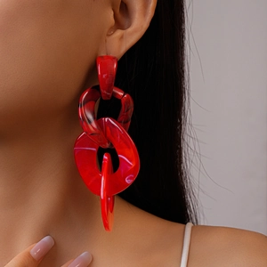 Close-up of red marble acrylic chunky chain drop earrings on a female model