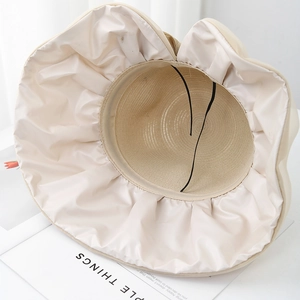 Detail view of beige sun hat with smooth inner lining and adjustable chin strap