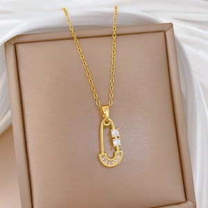 Titanium steel necklace with gold-plated zircon paperclip pendant on silk background