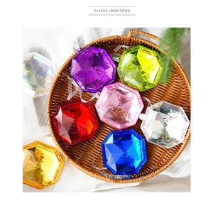 Detail of multi-color diamond-cut acrylic ornaments with white ribbons in a woven basket