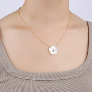 Golden necklace featuring a white shell flower pendant with central sparkling zircon stone