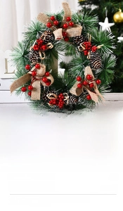 Close-up of artificial pine needles, red berries and burlap bow on Christmas wreath