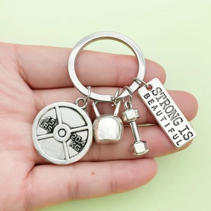 Silver fitness keychain with dumbbell, kettlebell, barbell and Strong Is Beautiful plate
