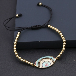 Detailed macro view of colorful zirconia evil eye pendant on black woven cord bracelet